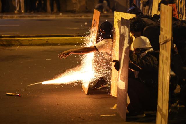 Demonstrators clash with anti-riot police officers during protests against Peru's interim President Jose Jeri in Lima on October 15, 2025.  (Photo by Hugo CUROTTO / AFP)
