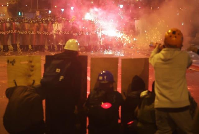 Demonstrators clash with anti-riot police officers during protests against Peru's interim President Jose Jeri in Lima on October 15, 2025.  (Photo by Hugo CUROTTO / AFP)
