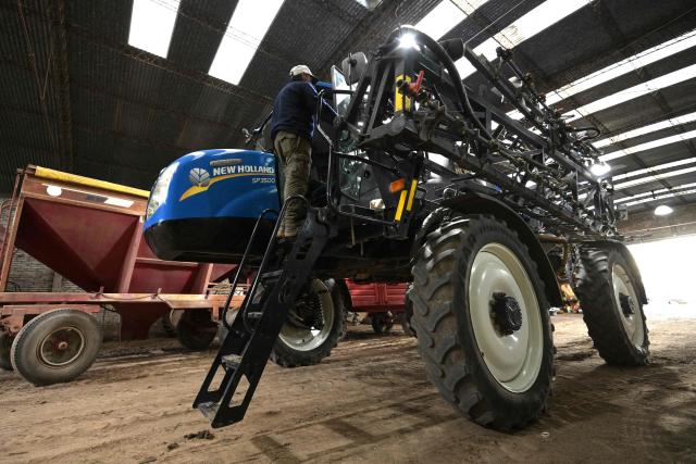 An employee of "Guanzini Hermanos S.A." checks a combine sprayer at Cucullu, a small town near the rural town of San Andres de Giles in Buenos Aires province, Argentina on September 24, 2025. Surrounded by wheat fields and dozing during siesta time, the farming town of San Andres de Giles voted for Javier Milei in 2023. Two years later, the enthusiasm has faded into disappointment and uncertainty, ahead of a crucial legislative election for the Argentine president. (Photo by JUAN MABROMATA / AFP)