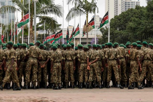 TOPSHOT - Kenyan National Youth Service officers stand in front of Kenyan flags flying half mast in Nairobi on October 16, 2025  following the death of Kenyan opposition leader Raila Odinga at the age of 80 during a health visit to India. Kenyan opposition leader Raila Odinga has died at the age of 80 during a health visit to India, local police said on October 15, 2025.
Odinga was the perennial opposition figure of Kenyan politics, running unsuccessfully for the presidency on five occasions, most recently in 2022. 
He remained a dominant force, able to rally huge numbers, particularly from his native western Kenya. (Photo by SIMON MAINA / AFP)