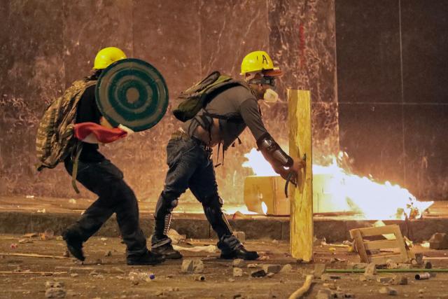 Demonstrators clash with anti-riot police officers during protest against Peru's interim President Jose Jeri in Lima on October 15, 2025. Violence at a rally in Peru's capital on Wednesday left at least 55 police officers and 20 civilians injured, President Jose Jeri, who assumed the top role less than a week ago, said. (Photo by Connie FRANCE / AFP)