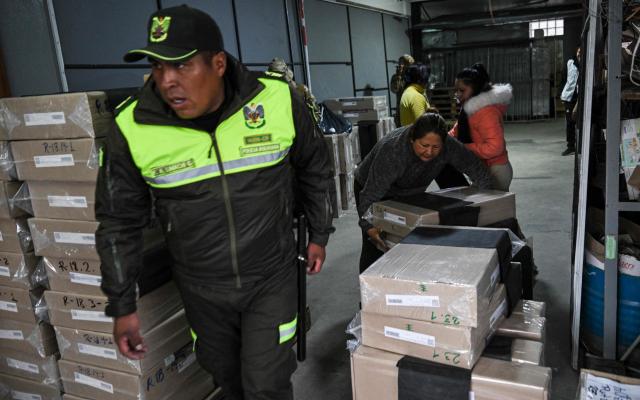 Electoral Tribunal staff members distribute electoral materials at the Electoral Logistics Distribution Center, in La Paz, on October 16, 2025. Bolivia will hold the runoff presidential election on October 19, 2025. (Photo by MARTIN BERNETTI / AFP)