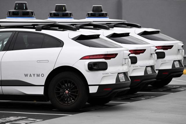 (FILES) A Waymo autonomous self-driving Jaguar electric vehicle sits parked at an EVgo charging station in Los Angeles, California, on May 15, 2024. US food delivery app DoorDash announced October 15, 2025 that Waymo driverless cars will soon shuttle orders to some customers in a budding partnership with the Google-owned robotaxi star. The alliance will start in coming months with Waymo cars delivering take-away meals, groceries and convenience shop items to DoorDash users in the southwestern US city of Phoenix, according to the companies. (Photo by Patrick T. Fallon / AFP)