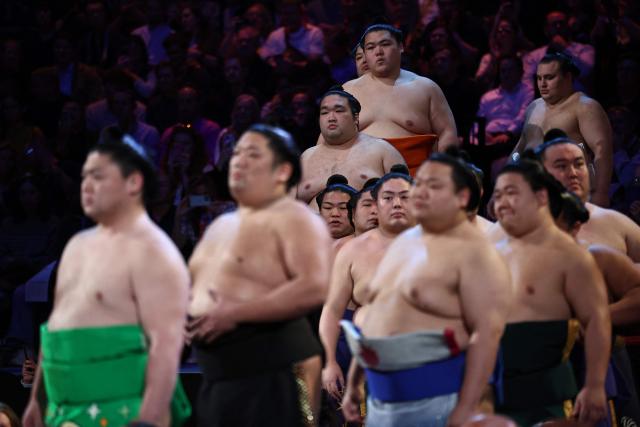 Rikishi take part in the ring entering ceremony on day 2 of the Grand Sumo Tournament at the Royal Albert Hall in central London on October 16, 2025. (Photo by HENRY NICHOLLS / AFP)