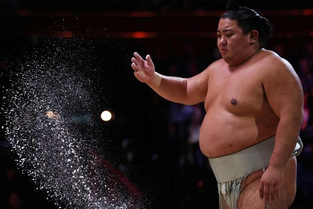 Hitoshi throws salt before his bout during the Grand Sumo Tournament at the Royal Albert Hall in central London on October 16, 2025. (Photo by HENRY NICHOLLS / AFP)