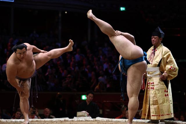 Tobizaru (L) and Kotoeiho (R) stamp the ground before their bout during the Grand Sumo Tournament at the Royal Albert Hall in central London on October 16, 2025. (Photo by HENRY NICHOLLS / AFP)