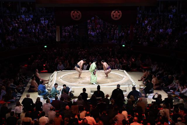 Wakamotoharu (L) faces Roga (R) during their bout on day 2 of the Grand Sumo Tournament at the Royal Albert Hall in central London on October 16, 2025. (Photo by HENRY NICHOLLS / AFP)