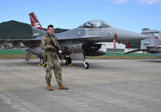 A US soldier stands guard in front of an F-16 fighter jet during the Seoul International Aerospace and Defence Exhibition (ADEX) at a military airport in Seongnam on October 17, 2025. (Photo by Jung Yeon-je / AFP)