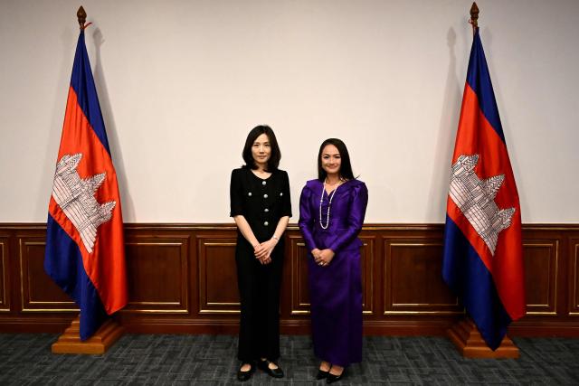 South Korea's Second Vice Foreign Minister Kim Jin-a (L) poses for photographs with Cambodian Secretary of State, Ministry of Foreign Affairs and International Cooperation Yentieng Puthirasmey during a meeting at the Ministry of Foreign Affairs and International Cooperation building in Phnom Penh on October 17, 2025. Two South Koreans detained in a crime crackdown by Cambodian authorities returned home on October 17, police said, a day after Phnom Penh announced plans to deport 59 Koreans accused of working in cyberscam operations. (Photo by TANG CHHIN Sothy / AFP)