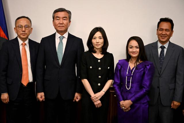 South Korea's Second Vice Foreign Minister Kim Jin-a (C) and Head of the National Investigation Headquarters of the National Police Agency Park Sung-Joo (2nd L) pose for photographs with Cambodian Secretary of State, Ministry of Foreign Affairs and International Cooperation Yentieng Puthirasmey (2nd R) during a meeting at the Ministry of Foreign Affairs and International Cooperation building in Phnom Penh on October 17, 2025. Two South Koreans detained in a crime crackdown by Cambodian authorities returned home on October 17, police said, a day after Phnom Penh announced plans to deport 59 Koreans accused of working in cyberscam operations. (Photo by TANG CHHIN Sothy / AFP)