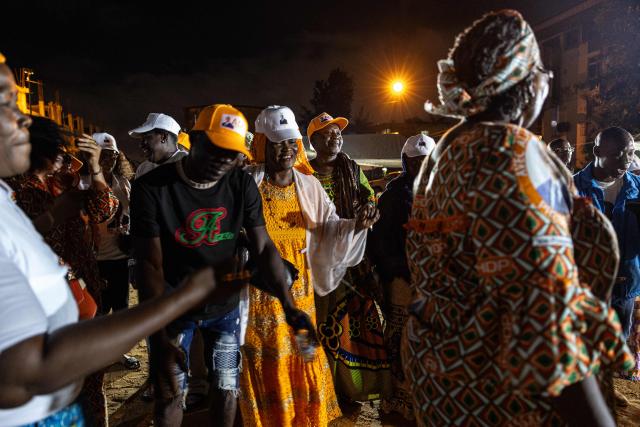 Supporters of Ivorian President and presidential candidate for Rally of Houphouetists for Democracy and Peace (RHDP) Alassane Ouattara dance during a political gathering ahead of the upcoming presidential election in Cocody near Abidjan on October 16, 2025. (Photo by EMMANUEL CROSET / AFP)