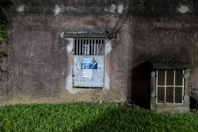 A poster of Ivorian President and presidential candidate for Rally of Houphouetists for Democracy and Peace (RHDP) Alassane Ouattara hangs on a wall ahead of the upcoming presidential election in Cocody near Abidjan on October 16, 2025. (Photo by EMMANUEL CROSET / AFP)
