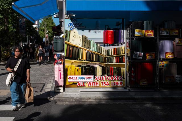 Pedestrians walk in Akihabara district of Tokyo on October 17, 2025. (Photo by Philip FONG / AFP)