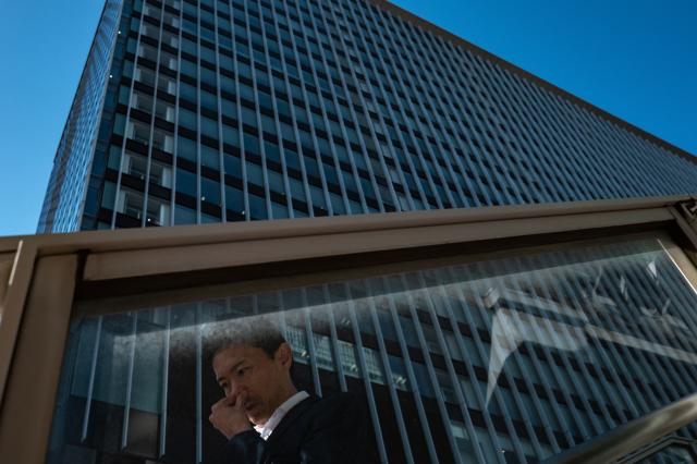 A man gestures as he walks in Akihabara district of Tokyo on October 17, 2025. (Photo by Philip FONG / AFP)