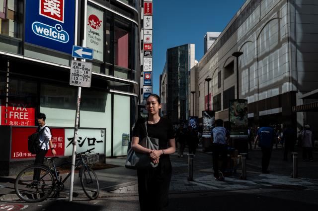 Pedestrians walk in Akihabara district of Tokyo on October 17, 2025. (Photo by Philip FONG / AFP)
