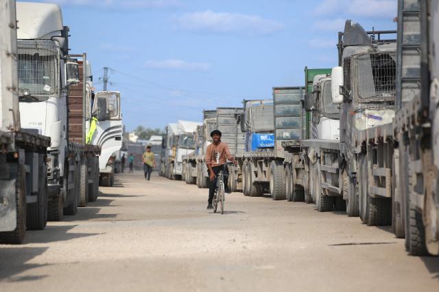Truck carrying aid provided by the World Food Programme (WFP) wait at the Kissufim crossing, located east of Deir el-Balah in the central Gaza Strip, before entering the Palestinian enclave on October 17, 2025. (Photo by BASHAR TALEB / AFP)