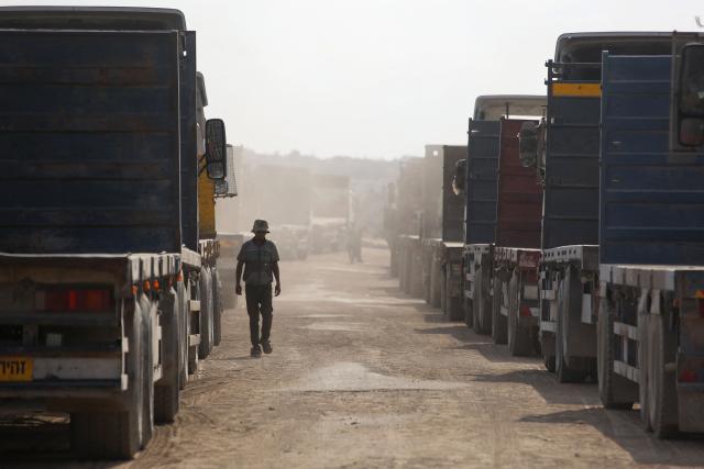TOPSHOT - Truck carrying aid provided by the World Food Programme (WFP) wait at the Kissufim crossing, located east of Deir el-Balah in the central Gaza Strip, before entering the Palestinian enclave on October 17, 2025. (Photo by BASHAR TALEB / AFP)
