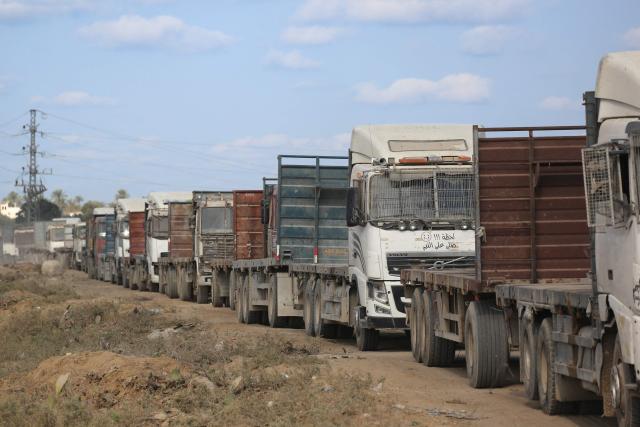 Truck carrying aid provided by the World Food Programme (WFP) wait at the Kissufim crossing, located east of Deir el-Balah in the central Gaza Strip, before entering the Palestinian enclave on October 17, 2025. (Photo by BASHAR TALEB / AFP)
