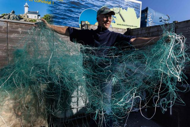 French charity association "Kernic Solidarites" member in charge of logistic Christian Abaziou sorts out fishnets collected by the association to be send to Ukraine and use as protections against drone attacks, in the Britany port of Roscoff, on October 17, 2025. (Photo by Fred TANNEAU / AFP)