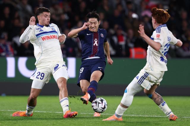 Paris Saint-Germain's South Korean midfielder #19 Lee Kang-in (C) fights for the ball with Strasbourg's French midfielder #29 Samir El Mourabet (L) and Strasbourg's Argentine midfielder #32 Valentin Barco (R) during the French L1 football match between Paris Saint-Germain (PSG) and RC Strasbourg Alsace at the Parc des Princes Stadium in Paris on October 17, 2025. (Photo by FRANCK FIFE / AFP)
