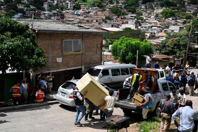 Residents leave El Reparto neighborhood after a landslide, triggered by heavy rains, destroyed several homes in Tegucigalpa, on October 17, 2025. Heavy rains affecting various regions of Honduras since late September have left fifteen people dead and more than 24,000 affected, according to the Secretariat for Risk and Contingency Management (COPECO). (Photo by Orlando SIERRA / AFP)