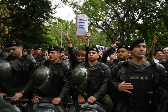 Opponents of Argentina's President Javier Milei demonstrate before his arrival for a campaign rally in Buenos Aires, on October 17, 2025, ahead of the upcoming legislative elections. Milei, once a global poster boy for budget-slashing libertarian politics, is heading into the polls diminished by his failure to stabilize Argentina's ailing peso despite spending nearly all the Central Bank's dollar reserves to prop it up. (Photo by Luis ROBAYO / AFP)