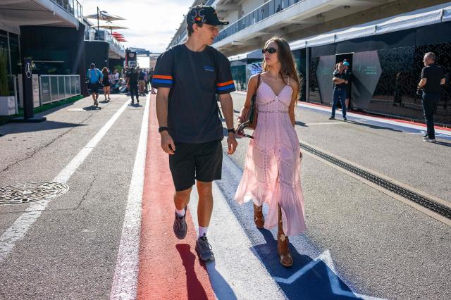 McLaren's Australian driver Oscar Piastri walks with girlfriend Lily Zneimer in the paddock ahead of the practice session for the United States Formula One Grand Prix at the Circuit of the Americas in Austin, Texas, on October 17, 2025. (Photo by Jim WATSON / AFP)