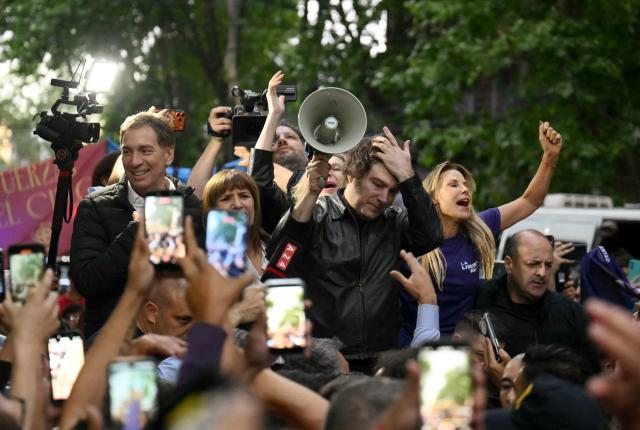 Argentina's President Javier Milei gestures as he addresses supporters, accompanied by Security Minister Patricia Bullrich (2-L) and leading candidate Diego Santilli (L), during a campaign rally ahead of the upcoming legislative elections, in Buenos Aires on October 17, 2025. Milei, once a global poster boy for budget-slashing libertarian politics, is heading into the polls diminished by his failure to stabilize Argentina's ailing peso despite spending nearly all the Central Bank's dollar reserves to prop it up. (Photo by Luis ROBAYO / AFP)