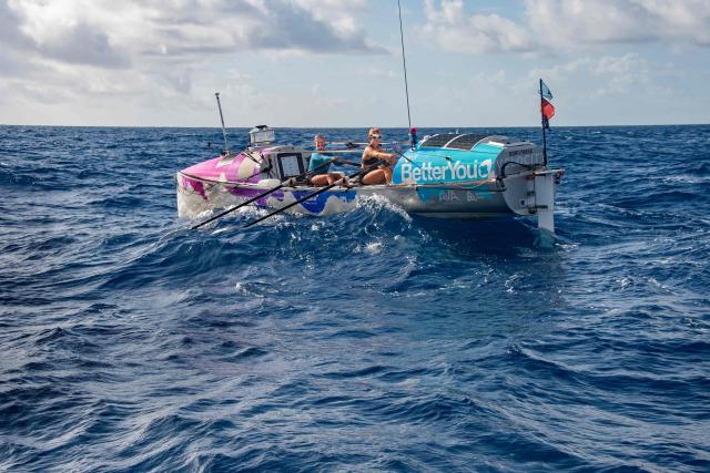 British rowers Jess Rowe (L) and Miriam Payne row in their vessel named "Velocity" as they approach Australia's Great Barrier Reef in the Coral Sea on October 17, 2025. The pair left Peru on May 5 to travel the 9,000 miles (14,500 kilometres) journey across the Pacific Ocean to Australia, raising money for charity and attempting to become the first women's team and the first pair to row across the Pacific Ocean non-stop and unsupported. (Photo by Brian CASSEY / AFP)
