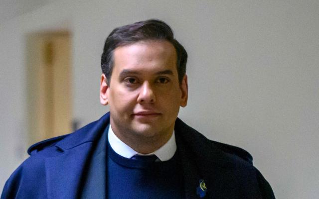 (FILES) Rep. George Santos, R-NY, walks from his office to the US Capitol in Washington, DC, on December 1, 2023. President Donald Trump on October 17, 2025 commuted the sentence of disgraced former Republican lawmaker George Santos, who was convicted of committing wire fraud and identity theft to splurge on lavish vacations and Botox injections with funds stolen from campaign donors. (Photo by Mandel NGAN / AFP)