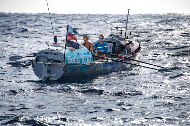 British rowers Jess Rowe (R) and Miriam Payne row in their vessel named "Velocity" as they approach Australia's Great Barrier Reef in the Coral Sea on October 17, 2025. The pair left Peru on May 5 to travel the 9,000 miles (14,500 kilometres) journey across the Pacific Ocean to Australia, raising money for charity and attempting to become the first women's team and the first pair to row across the Pacific Ocean non-stop and unsupported. (Photo by Brian CASSEY / AFP)