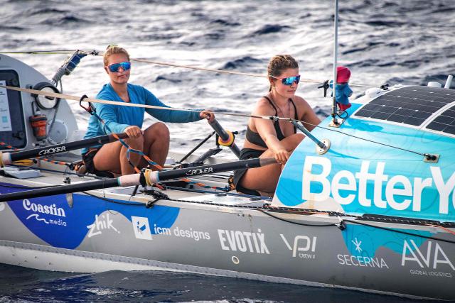 British rowers Jess Rowe (L) and Miriam Payne row in their vessel named "Velocity" as they approach Australia's Great Barrier Reef in the Coral Sea on October 17, 2025. The pair left Peru on May 5 to travel the 9,000 miles (14,500 kilometres) journey across the Pacific Ocean to Australia, raising money for charity and attempting to become the first women's team and the first pair to row across the Pacific Ocean non-stop and unsupported. (Photo by Brian CASSEY / AFP)