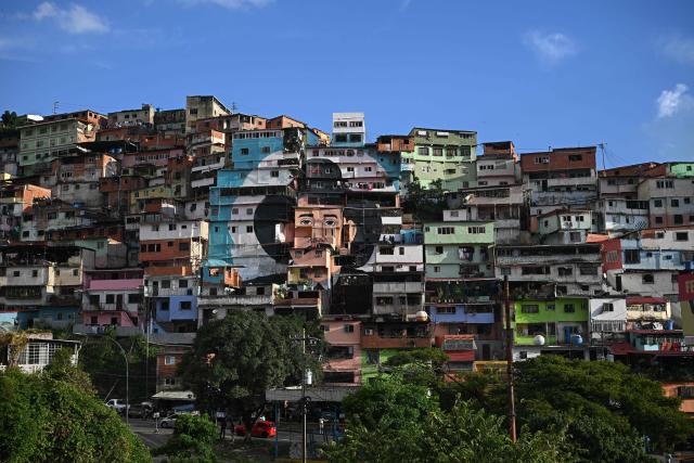 A giant mural of Venezuelan doctor Josй Gregorio Hernбndez, also known as "the doctor of the poor", is seen painted across the facades of several houses in the El Saman de Bolнvar community, in the Petare neighborhood of Caracas, on October 17, 2025. Pope Leo XIV is set to canonize Venezuela’s first saints, Dr. Jose Gregorio Hernandez and Sister Maria del Carmen Rendiles, during a ceremony in St. Peter's Square on October 19, 2025. (Photo by Federico PARRA / AFP)