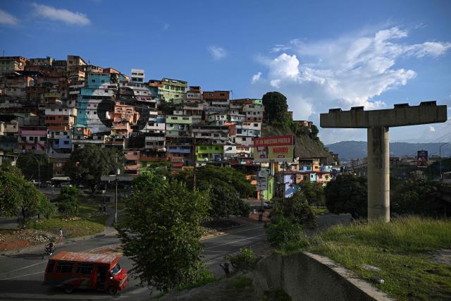A giant mural of Venezuelan doctor Josй Gregorio Hernбndez, also known as "the doctor of the poor", is seen painted across the facades of several houses in the El Saman de Bolнvar community, in the Petare neighborhood of Caracas, on October 17, 2025. Pope Leo XIV is set to canonize Venezuela’s first saints, Dr. Jose Gregorio Hernandez and Sister Maria del Carmen Rendiles, during a ceremony in St. Peter's Square on October 19, 2025. (Photo by Federico PARRA / AFP)