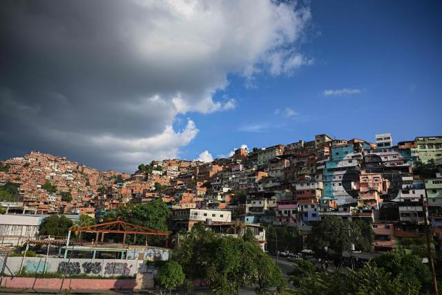A giant mural of Venezuelan doctor Josй Gregorio Hernбndez, also known as "the doctor of the poor", is seen painted across the facades of several houses in the El Saman de Bolнvar community, in the Petare neighborhood of Caracas, on October 17, 2025. Pope Leo XIV is set to canonize Venezuela’s first saints, Dr. Jose Gregorio Hernandez and Sister Maria del Carmen Rendiles, during a ceremony in St. Peter's Square on October 19, 2025. (Photo by Federico PARRA / AFP)