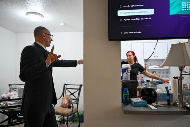 Nelva Ortega (R), wife of Cuban dissident Jose Daniel Ferrer (L), speaks to him in their house in Miami, Florida, on October 16, 2025. There's no rest for Jose Daniel Ferrer, a Cuban dissident who arrived in the United States on October 13 and is determined to work with other exiles to democratically unseat the communist government in Havana. "We have to be proactive if we want to encourage Cubans to fight for their rights, for their freedom, instead of leaving the country with a 'save yourself if you can' type of mentality," the longtime activist told AFP from his new home in Miami. (Photo by CHANDAN KHANNA / AFP)