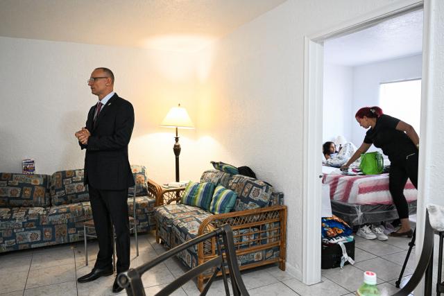 Nelva Ortega (R), wife of Cuban dissident Jose Daniel Ferrer (L), works as he speaks during an interview with AFP in their house in Miami, Florida, on October 16, 2025. There's no rest for Jose Daniel Ferrer, a Cuban dissident who arrived in the United States on October 13 and is determined to work with other exiles to democratically unseat the communist government in Havana. "We have to be proactive if we want to encourage Cubans to fight for their rights, for their freedom, instead of leaving the country with a 'save yourself if you can' type of mentality," the longtime activist told AFP from his new home in Miami. (Photo by CHANDAN KHANNA / AFP)