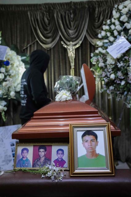 A mourner stands next to the coffin of Eduardo Ruiz, a demonstrator killed on October 15 during a protest against Peru's interim President Jose Jeri, in Lima on October 17, 2025. Peru's government on Friday suspended the police chief of the capital Lima after violent anti-government protests which left Ruiz dead and over 100 injured, according to a statement seen by AFP. (Photo by CONNIE FRANCE / AFP)