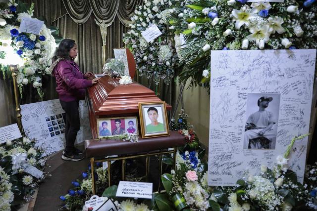 A woman stands next to the coffin of Eduardo Ruiz, a demonstrator killed on October 15 during a protest against Peru's interim President Jose Jeri, in Lima on October 17, 2025. Peru's government on Friday suspended the police chief of the capital Lima after violent anti-government protests which left Ruiz dead and over 100 injured, according to a statement seen by AFP. (Photo by CONNIE FRANCE / AFP)