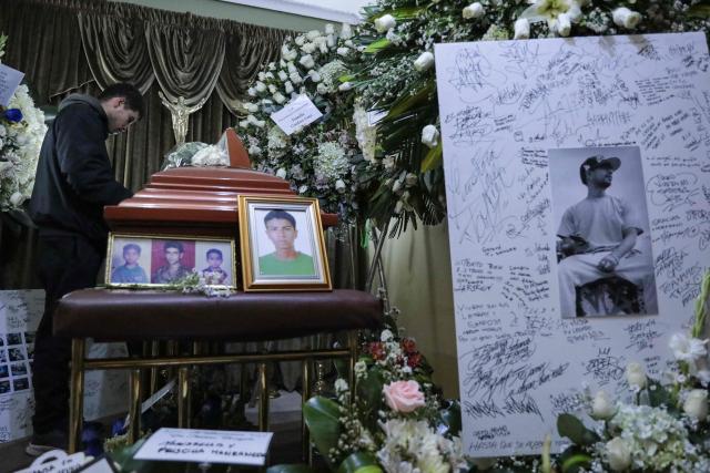 A mourner stands next to the coffin of Eduardo Ruiz, a demonstrator killed on October 15 during a protest against Peru's interim President Jose Jeri, in Lima on October 17, 2025. Peru's government on Friday suspended the police chief of the capital Lima after violent anti-government protests which left Ruiz dead and over 100 injured, according to a statement seen by AFP. (Photo by CONNIE FRANCE / AFP)