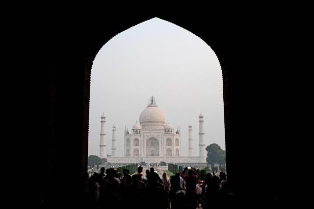 Tourists visit the Taj Mahal at sunrise in Agra on October 18, 2025. (Photo by Punit PARANJPE / AFP)