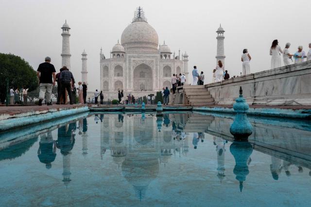 Tourists visit the Taj Mahal at sunrise in Agra on October 18, 2025. (Photo by Punit PARANJPE / AFP)