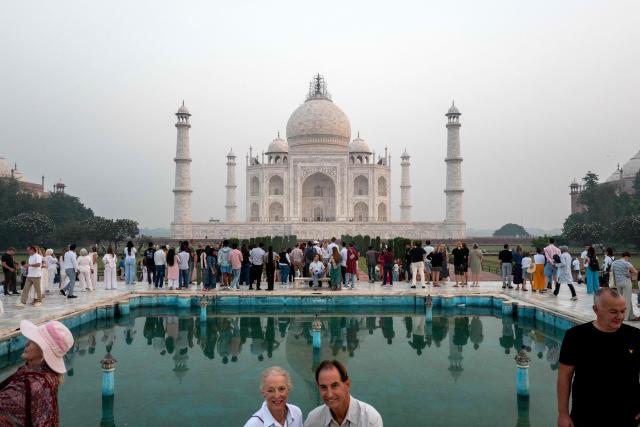 Tourists visit the Taj Mahal at sunrise in Agra on October 18, 2025. (Photo by Punit PARANJPE / AFP)