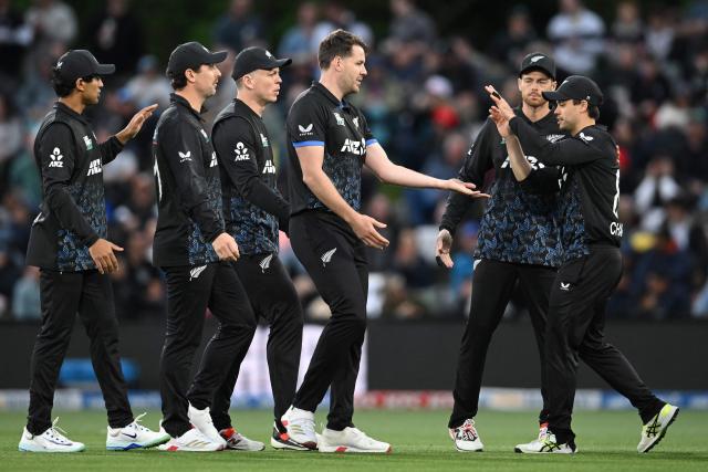 New Zealand's Mark Chapman (R) and Jacob Duffy celebrate after taking the wicket of England's Phil Salt during the first Twenty20 international cricket match between New Zealand and England at Hagley Oval in Christchurch on October 18, 2025. (Photo by Sanka VIDANAGAMA / AFP)