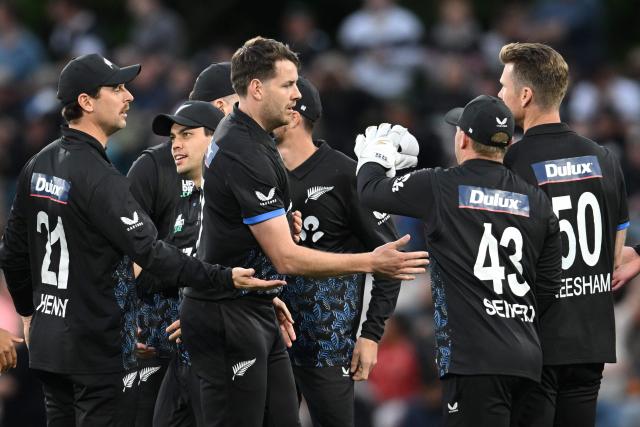 New Zealand's Jacob Duffy (C) celebrates with teammates after taking the wicket of England's Phil Salt during the first Twenty20 international cricket match between New Zealand and England at Hagley Oval in Christchurch on October 18, 2025. (Photo by Sanka VIDANAGAMA / AFP)