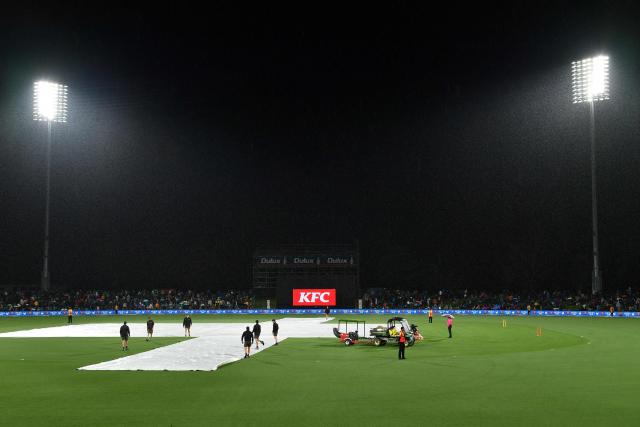A general view shows the covers on the pitch as rain delays the first Twenty20 international cricket match between New Zealand and England at Hagley Oval in Christchurch on October 18, 2025. (Photo by Sanka Vidanagama / AFP)