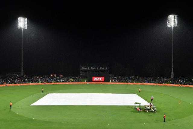 A general view shows the covers on the pitch as rain delays the first Twenty20 international cricket match between New Zealand and England at Hagley Oval in Christchurch on October 18, 2025. (Photo by Sanka Vidanagama / AFP)