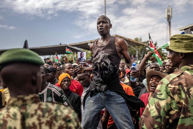 A supporter of Kenya’s opposition leader and former Prime Minister Raila Odinga confronts a security officer controlling the crowd as mourners line up to view Odinga’s coffin upon the arrival of his funeral proceedings to his home region in Kisumu, on October 18, 2025. Vast crowds gathered in western Kenya on October 18, 2025 to see the body of a beloved politician, Raila Odinga, for the biggest day of mourning ceremonies. (Photo by Luis TATO / AFP)
