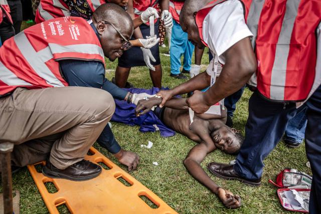 Medics from emergency services tend to a motionless man as a crowd of mourners and supporters of Kenya’s opposition leader and former Prime Minister Raila Odinga line up to view his coffin upon the arrival of the funeral proceedings to his home region in Kisumu, on October 18, 2025. Vast crowds gathered in western Kenya on October 18, 2025 to see the body of a beloved politician, Raila Odinga, for the biggest day of mourning ceremonies. (Photo by Luis TATO / AFP)