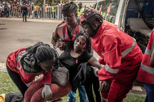 Medics from emergency services tend to an injured woman as a crowd of mourners and supporters of Kenya’s opposition leader and former Prime Minister Raila Odinga line up to view his coffin upon the arrival of the funeral proceedings to his home region in Kisumu, on October 18, 2025. Vast crowds gathered in western Kenya on October 18, 2025 to see the body of a beloved politician, Raila Odinga, for the biggest day of mourning ceremonies. (Photo by Luis TATO / AFP)